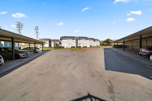 A parking lot with cars parked and a building in the background.