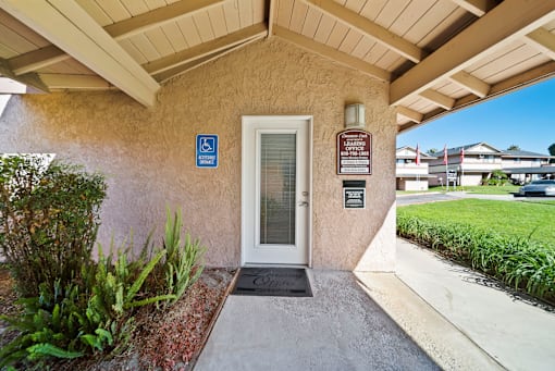 A building entrance with a ramp and a sign indicating it is handicap accessible.