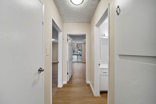 A hallway with white walls and a white door.