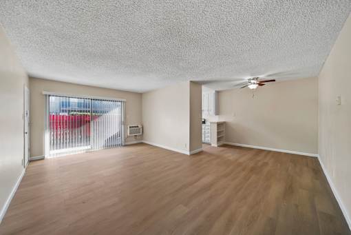 A room with wooden flooring and a ceiling fan.
