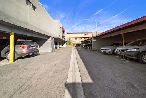 A parking lot with cars parked on both sides of the road.