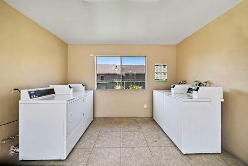 A room with two white appliances and a window.