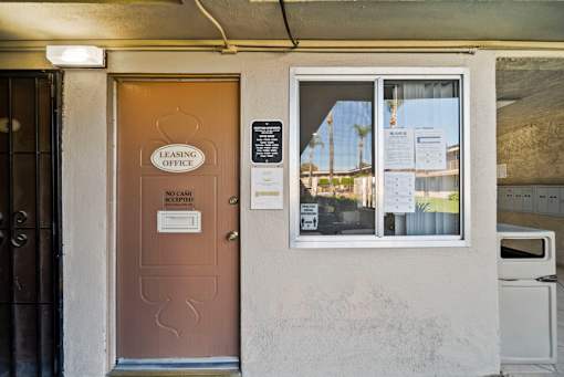 A brown door with a sign that says "Leasing Office" and "No Cash Receipts" on it.