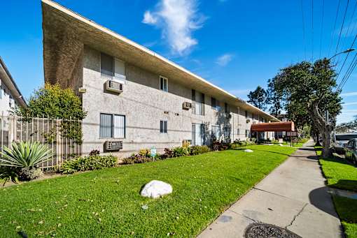 A concrete building with a green lawn in front.
