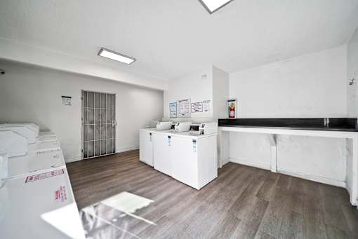 A white room with a white fridge and a white cupboard.