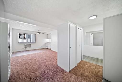 A room with white walls and a brown carpet.