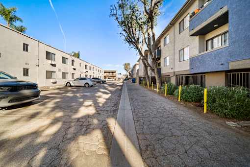 A street view of a residential area with cars parked on the side of the road.