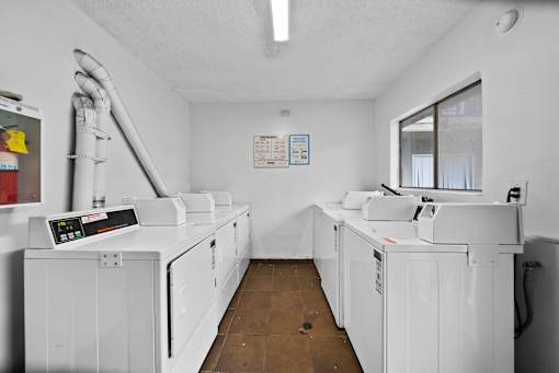 A clean, white-walled room with two large machines and a window.