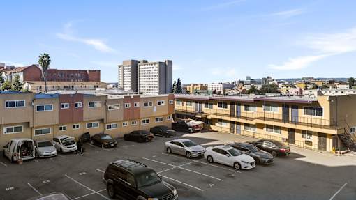 A parking lot with cars and apartment buildings in the background.