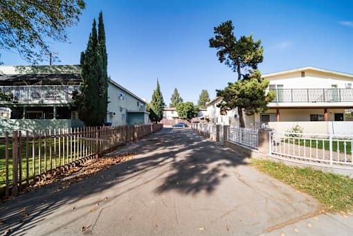 A residential street with houses on both sides and trees lining the street.