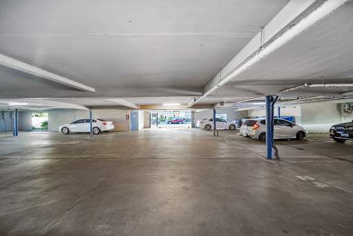A parking garage with several cars parked inside.