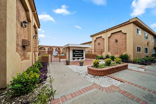 A building with a sign that says "Brick House" is surrounded by a garden and a brick pathway.