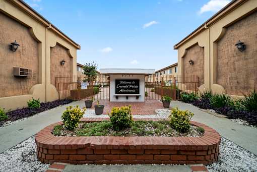 A garden in front of a building with a sign that reads "Welcome to Ansonia".