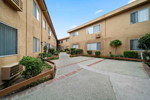 A courtyard surrounded by apartment buildings with a clear blue sky.