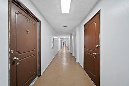 A hallway with doors on both sides and a door numbered 146.