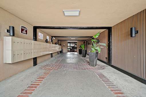 A long hallway with a brick floor and a white ceiling.