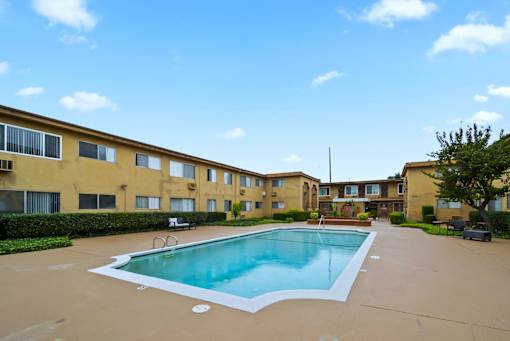 A swimming pool in front of apartment buildings.