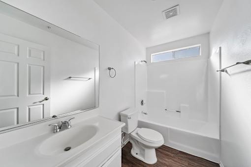 A white bathroom with a sink, toilet, and bathtub.