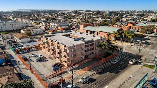 A view of a city from a high vantage point with buildings, cars, and a clear sky.