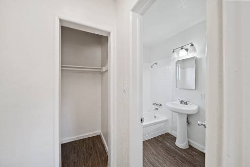 A white bathroom with a sink and a mirror.