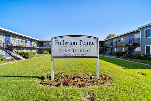 A sign for Fullerton Pointe Apartment Homes stands in front of apartment buildings.