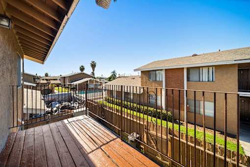 A balcony with a wooden floor and a metal railing.
