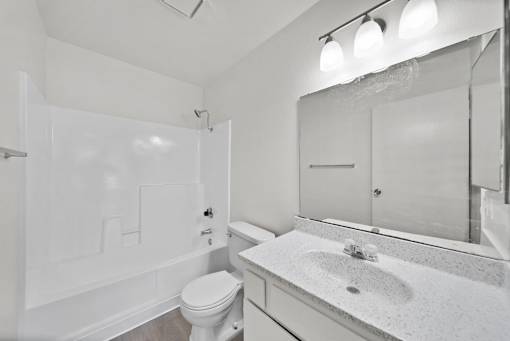 A white bathroom with a toilet, sink, and bathtub.