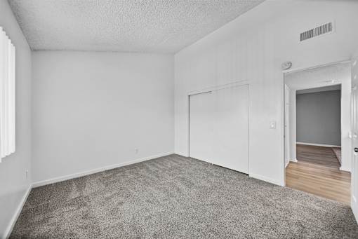 A room with a grey carpet and white walls.