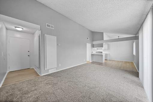 A spacious room with a carpeted floor and white walls.