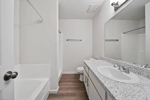 A white bathroom with a sink, toilet, and bathtub.