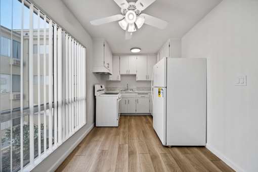 A kitchen with white appliances and cabinets is shown.