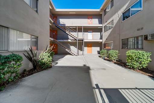 A concrete courtyard with a staircase leading to a building.