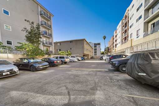 A parking lot with cars and buildings in the background.