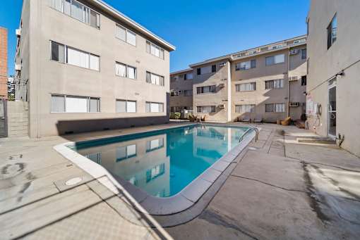 A swimming pool in a courtyard surrounded by buildings.