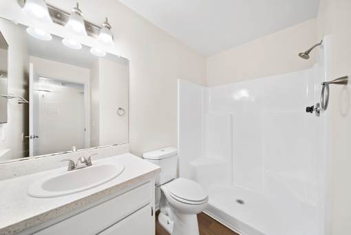 A white bathroom with a sink, toilet, and bathtub.