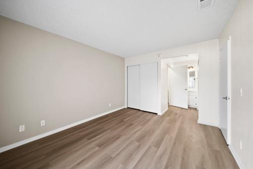A room with wooden flooring and white walls.