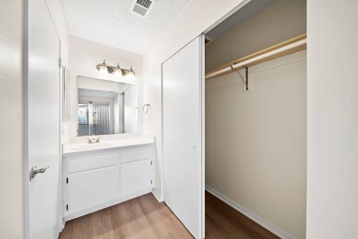 A white bathroom with a sink and a mirror.