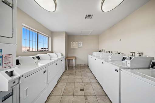 A laundromat with washers and dryers is shown.