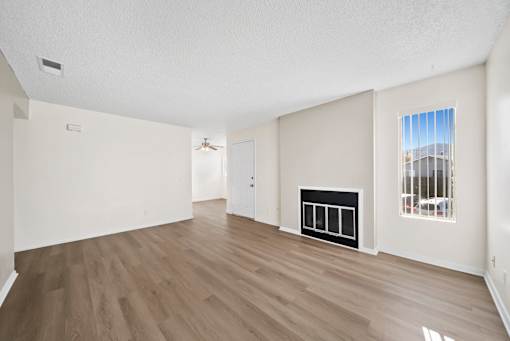 A room with a fireplace and a window overlooking a cityscape.