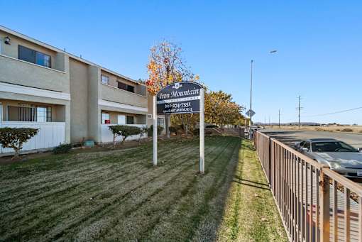 A sign for Iron Mountain Apartments stands in front of a building.