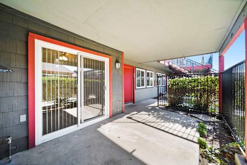 A red door with a glass window is on the left side of the image.