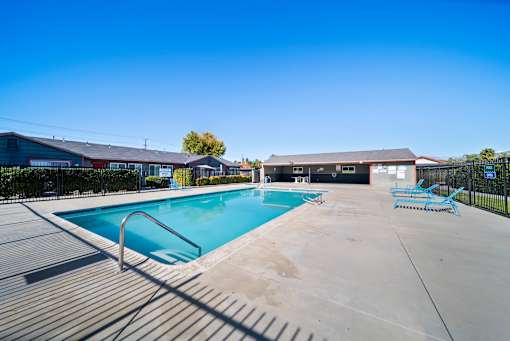 A large outdoor swimming pool with a metal ladder.