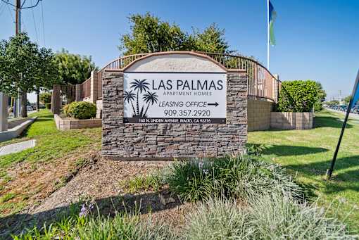 A sign for Las Palmas Apartment Homes with a phone number and address.