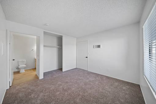 A large, empty room with a carpeted floor and white walls.