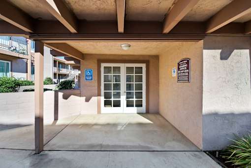 A building entrance with a blue sign on the wall.