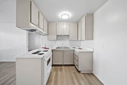 A kitchen with white appliances and cabinets.