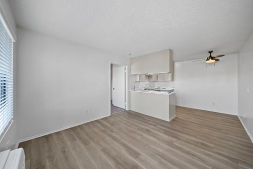 A room with a ceiling fan and a white cabinet.