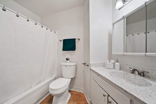A white toilet with a white sink and a white bathtub with a shower curtain.