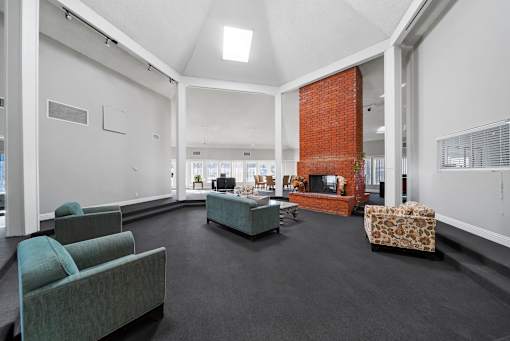 A living room with a grey couch and a red brick fireplace.
