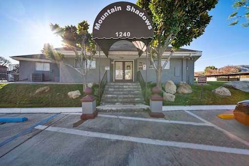 The image shows a building with a sign that reads "Mountain Shadows 1240".